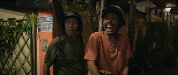 Two men laugh in a street scene from "Cocote Tonggo".