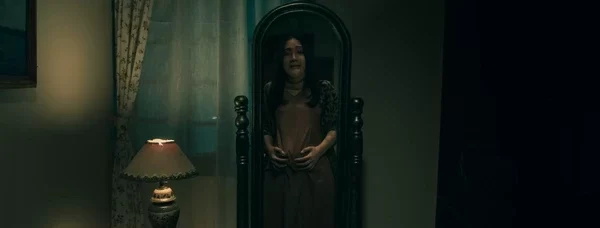 A woman appears distressed in front of a mirror, likely haunted by Jin Dasim in "Dasim".