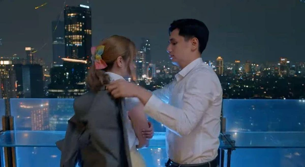 Leo and Februari share a romantic moment against a city night view in "Leo di Februari".
