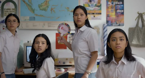 Girls in school uniforms stand in a classroom in the movie Rangga & Cinta.