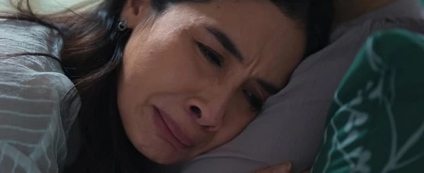 A woman lies in bed crying in "Lyora: Penantian Buah Hati".